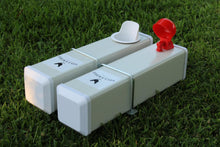 Load image into Gallery viewer, A manual livestock feeder and waterer combo on grass, predominantly white in color with a red valve on the water container.